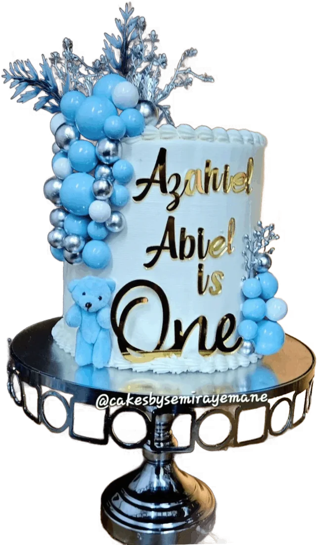 Blue first birthday cake with balloon spheres and gold lettering