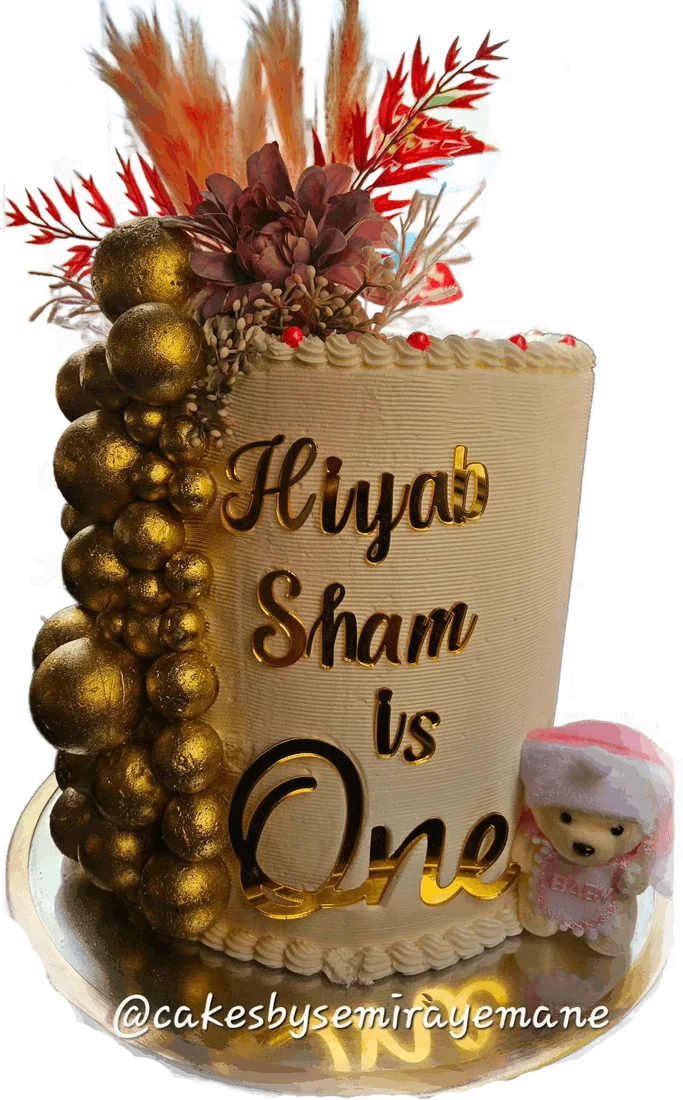 Gold first birthday cake with balloon spheres and dried flowers