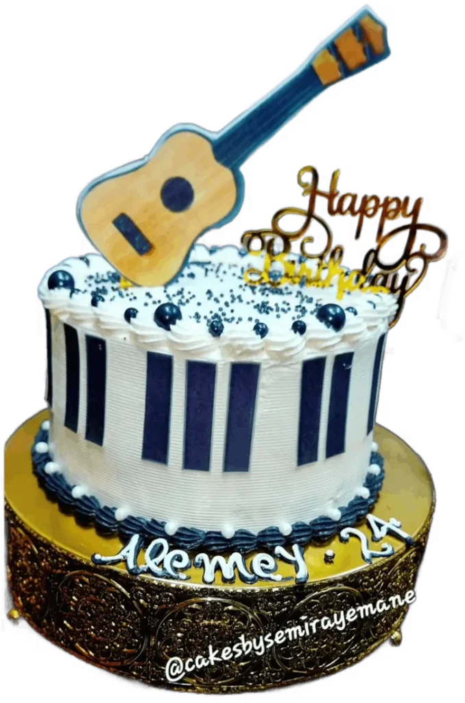Navy and white birthday cake with a guitar topper