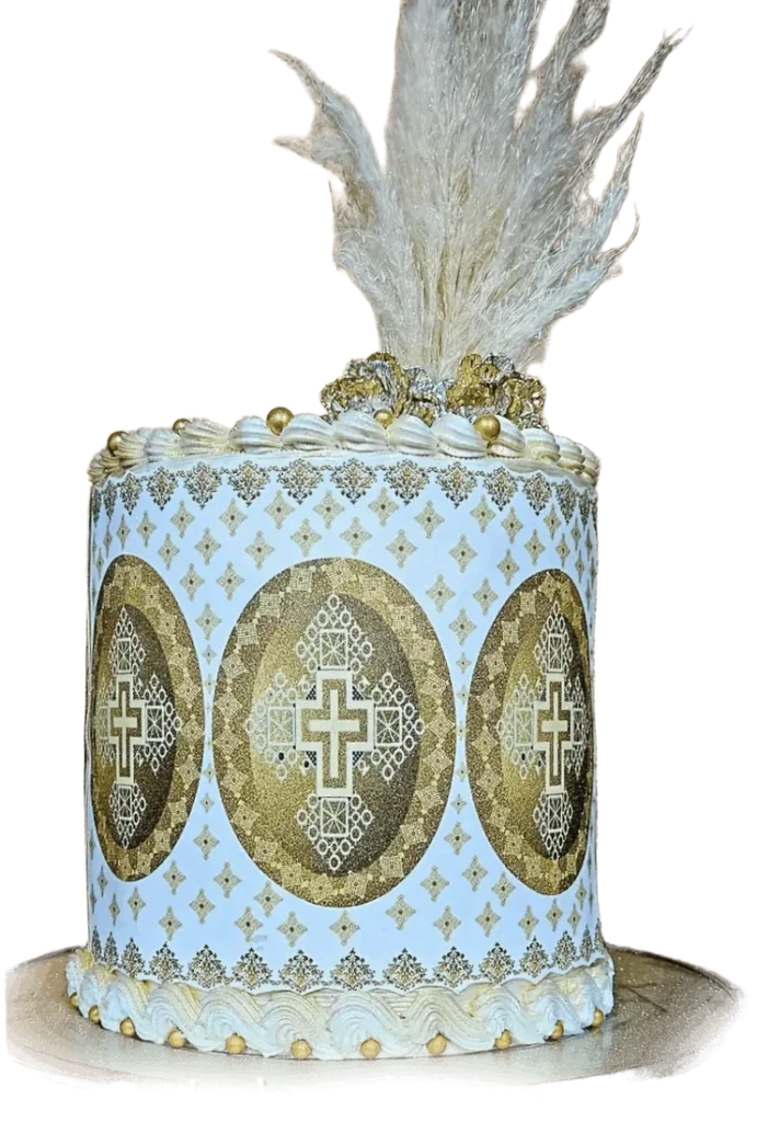 Pale blue celebration cake with gold medallions and white feathers