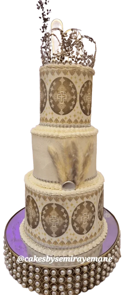 Tall wedding cake with Eritrean-style patterned tiers and gold topper